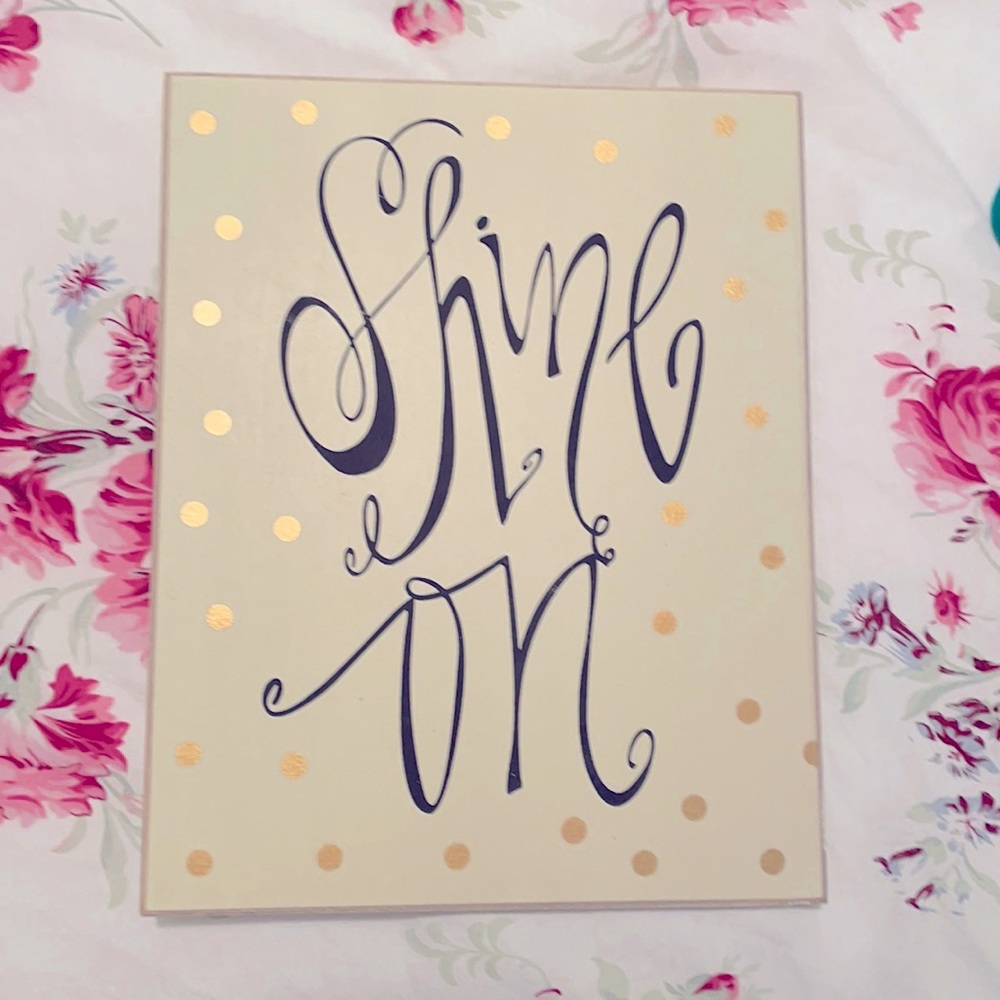 Wooden sign saying “SHINE ON”